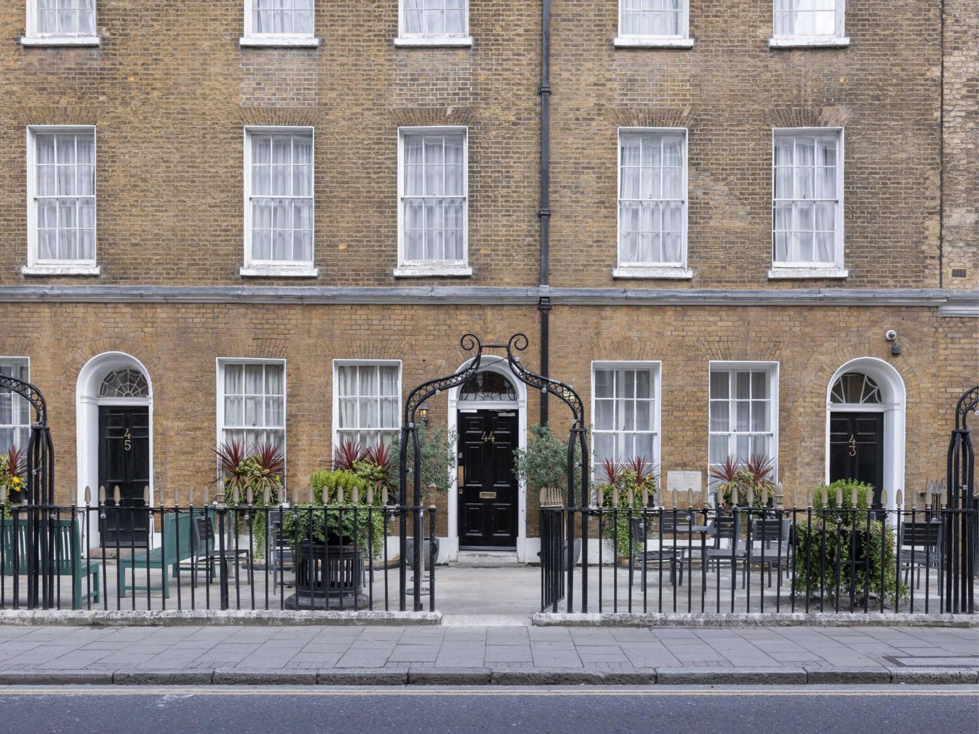 Montcalm Brewery Townhouse Hotell London Eksteriør bilde The photo shows a row of three-story brick buildings, featuring a classic design with large windows and decorative ironwork. The buildings are painted in a muted yellow-brown color, typical of older urban architecture. In front of the buildings, ther