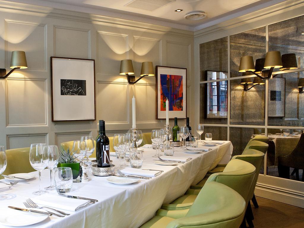 Montcalm Brewery Townhouse Hotell London Eksteriør bilde The photo shows an elegant restaurant setting with a long dining table that is neatly set for a meal. The table is adorned with a white tablecloth, glassware, and silverware, indicating that it is prepared for a special gathering or event. 

Behind t