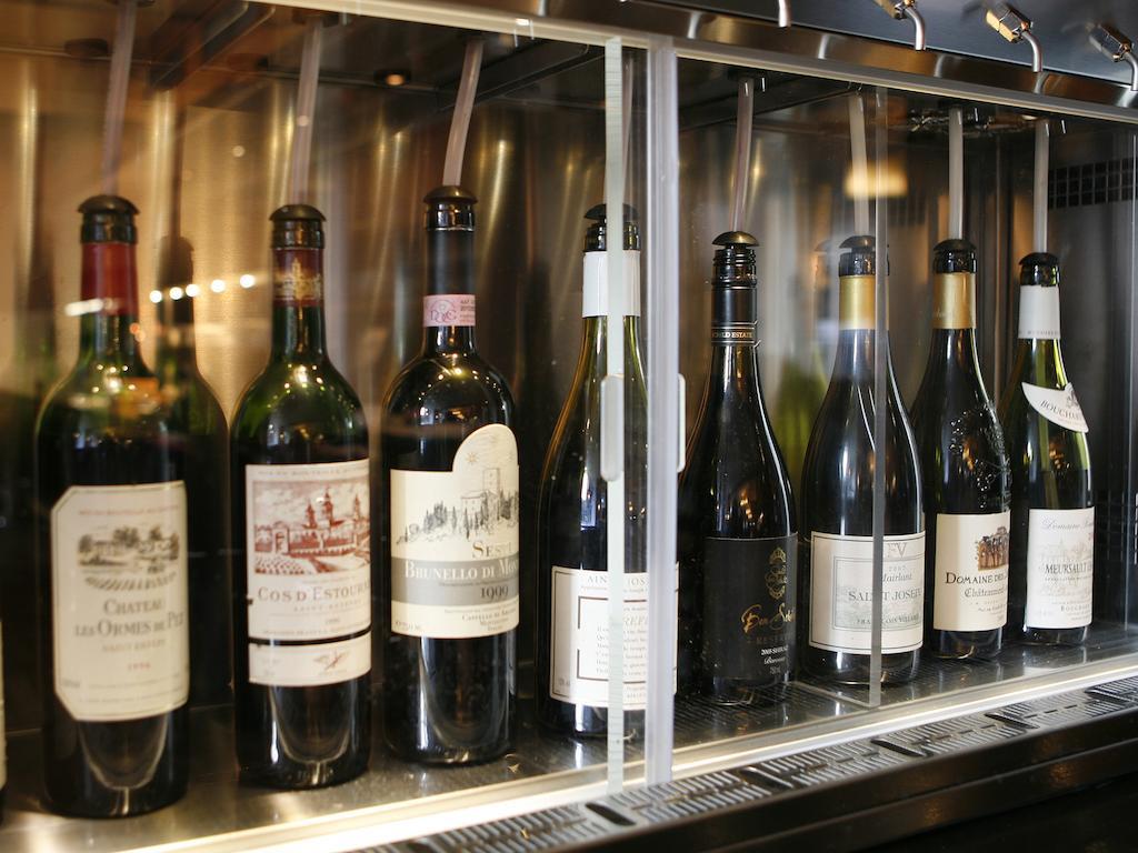 Montcalm Brewery Townhouse Hotell London Eksteriør bilde The photo depicts a selection of wine bottles displayed in a wine fridge or cooler. The bottles are lined up behind a glass panel, showcasing various types of wine, likely including both red and white varieties. Each bottle has a distinctive label, i